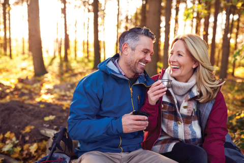 Middle ages couple looking happy, sat in a woodland