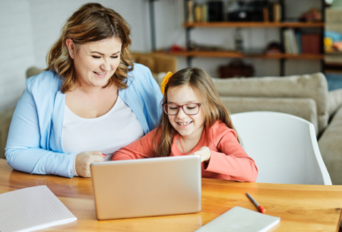 A mother and daughter on their laptop