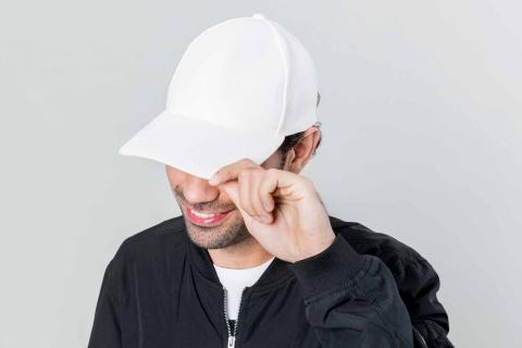 Man wearing a cap, partially covering his face