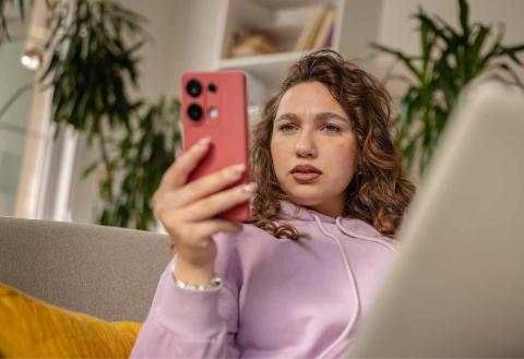 A woman looking confused at her phone