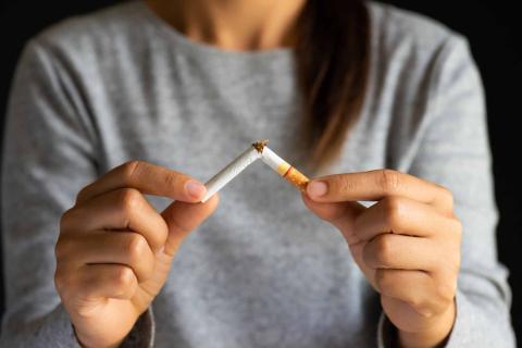 Woman breaking a cigarette in half