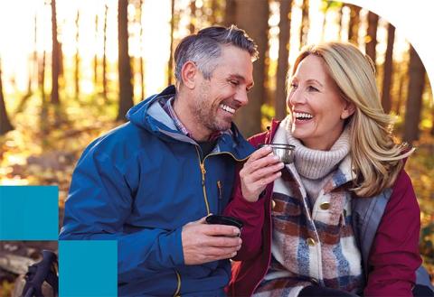 Two adults drinking coffee in autumn